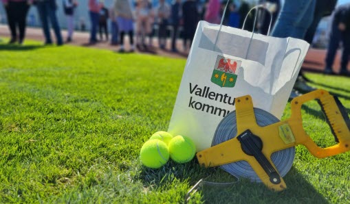 Tennisbollar och ett måttband ligger på gräsmattan under Funkisspelen 2022.