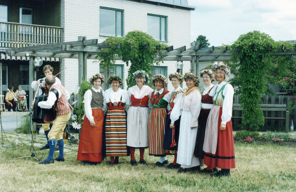 Vallentuna folkdansförening uppträder traditionsenligt vid Väsbygården midsommar 1992.  Spelmän är Lasse Widén och Gunnar Pettersson.   Dansare fr v Marita Lindberg, Anita Hofving, Elisabeth Hallqvist, Elvy Sundberg, Maria Ehrman, Lotta Zackrisson, Ellevi Gisselberg och Karin Vorwerk