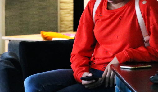 En person i röd tröja som sitter på en stol