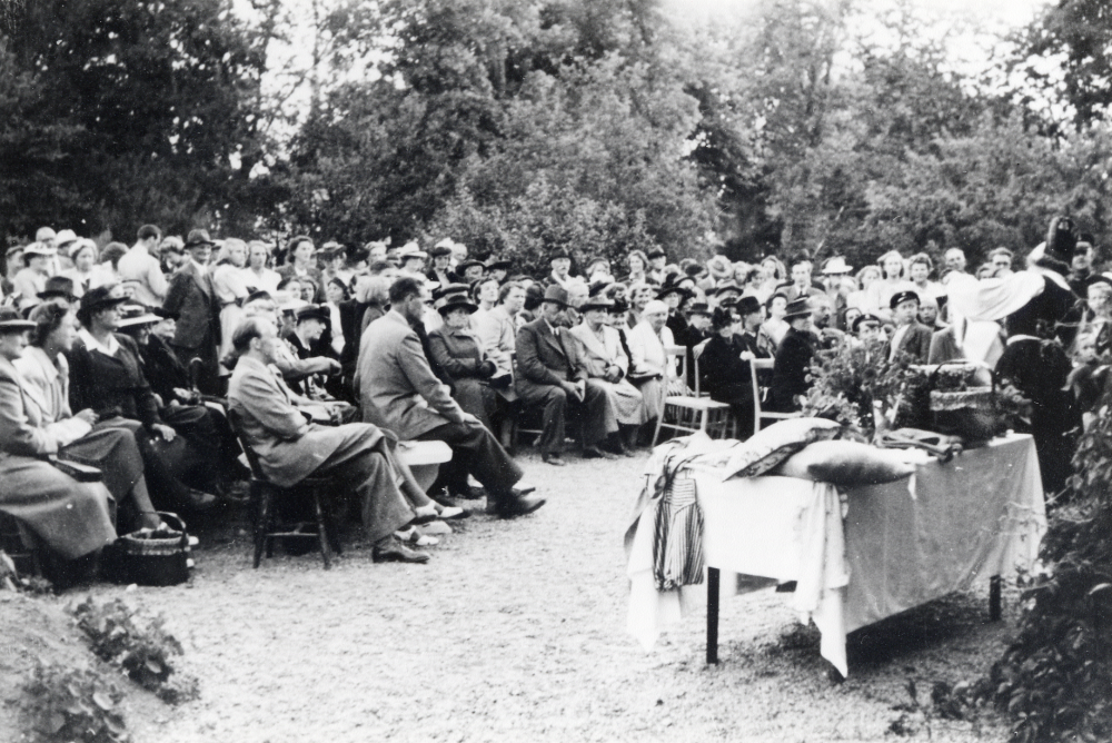 Vallentuna kyrkliga syförening håller auktion vid sommarfesten i Vallentuna prästgård.  Längst t h står lärarinnan Margit Oppermann, klädd i Häverödräkt.  Hon var alltid med vid dessa fester tillsammans  med auktionsutroparen kontraktsprost Sven Vängby och skrivaren John Edman