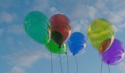 Färgglada ballonger med blå himmel i bakgrunden.