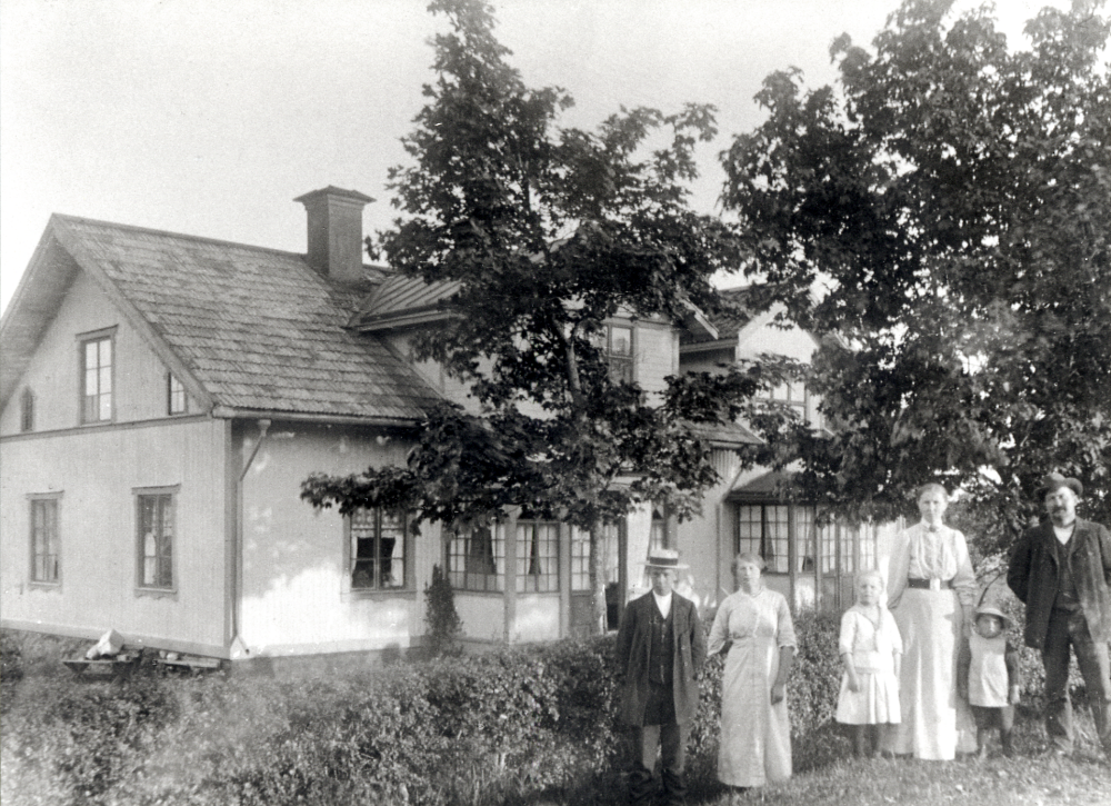 Ösby, Össeby-Garn.  Framför huset står fr v drängen Henning Kraemer, fadern var statare vid Brottby och bodde i Kvarnstugan, pigan Alma från Alby som senare gifte sig med Arvid Gustavsson, torpare vid Sjötorp i Hakunge och fick 11 barn, dottern Thyra född 1908 modern Eufrosyne kallad Syna, sonen Sven född 1912 och fadern Karl Dahlbeck