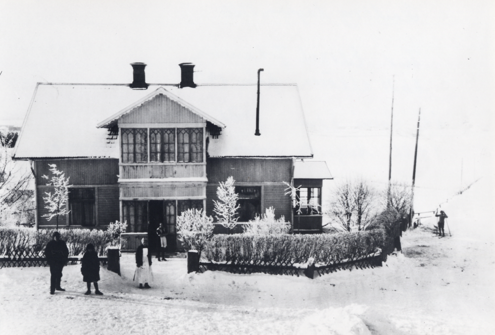 Karlborgs handelsbod låg mittemot Angarns kyrka. T v står Edvard Johansson som arrenderade affären från 1919. I vitt förkläde Augusta Lundin, ägare till affären, längst t h står hennes dotter Karin Lundin senare gift Edman.