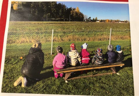 Barn som sitter på en bänk