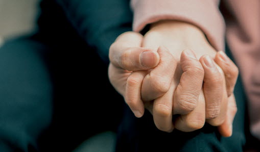 Två personer håller varandra i handen