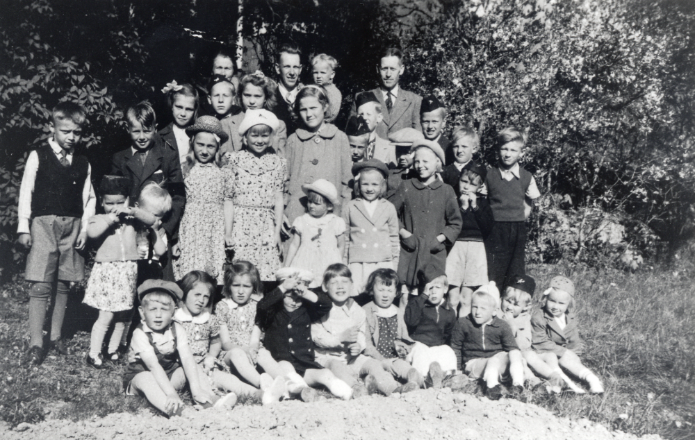 Söndagsskola i Betaniakapellet i början av 1940-talet.  Stående bakre raden fr v, Märta Johansson Vadaby, Nils Johansson Gläntan  *1916 med sonen Kjell  *1938 på armen och någon från Betelsemenariet.  Rad 2 fr v Per-Ola? Karlsson, Rune Alstermark, Maj-Britt Stjärnholm, Bengt Karlsson?, Siv Kraemer, Börje Alstermark, Björn Adegran, Arne Stjärnholm, Harry Frölin, Ingvar Thörnblom och Sven Wester. Rad 3 fr v okänd, okänd, okänd, Vivian Kraemer, okänd, okänd, Gunvor Ericsson, Birgit Karlsson och okänd.  Rad 4 sittande fr v: Arne Lundberg, Birgit Lundberg, okänd, okänd, Britt Andersson, Ulla Andersson, Sven-Eric Ericsson, Gunnar Söderström, okänd och Kerstin Alstermark
