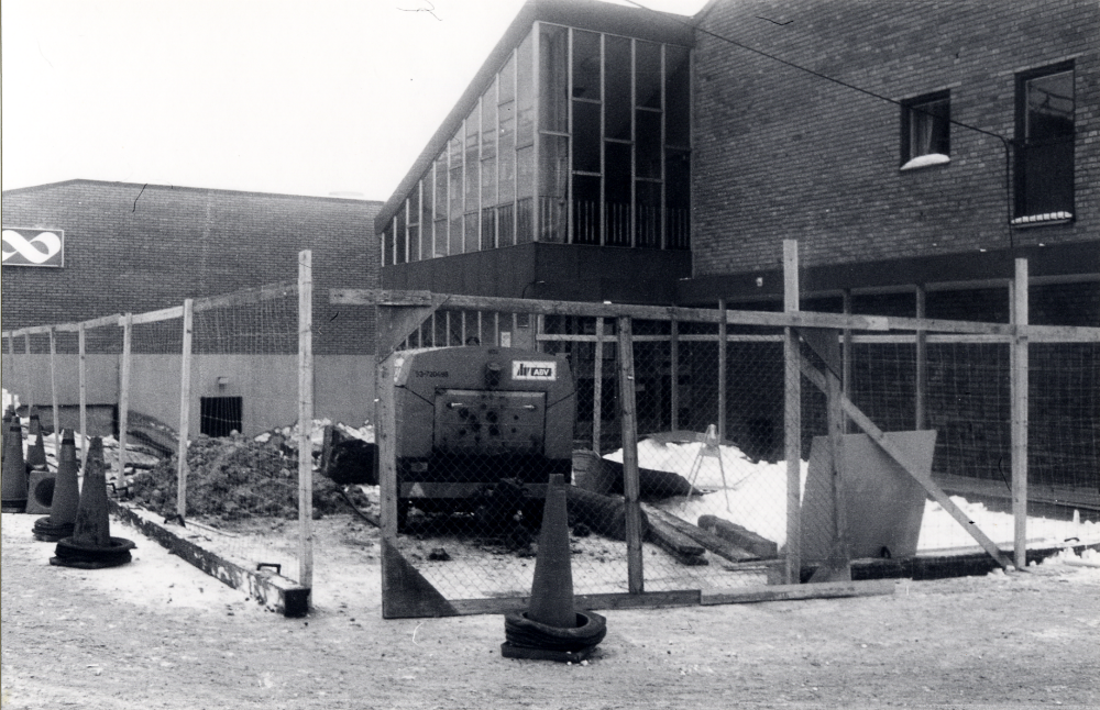 Gamla Konsumhuset byggs om med en utbyggnad på västra entrésidan, ingången till Vallentuna bibliotek med adress Allévägen 2. Bakom Konsumhuset ses det nya Domusvaruhuset.