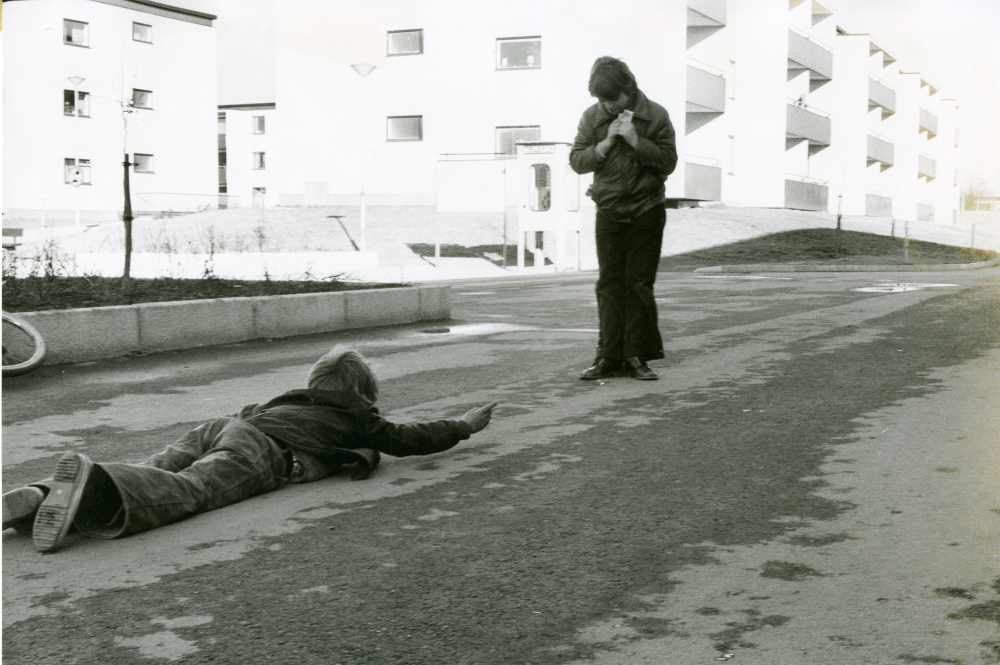 Två barn spelar kula på gatan vid Sörgården våren 1973.
•Fotografiet ingår i bildserien ”Vardagsliv i Vallentuna kommun” av Rachael Gough-Azmier & Gunilla Blomé, Haga Studios HB.