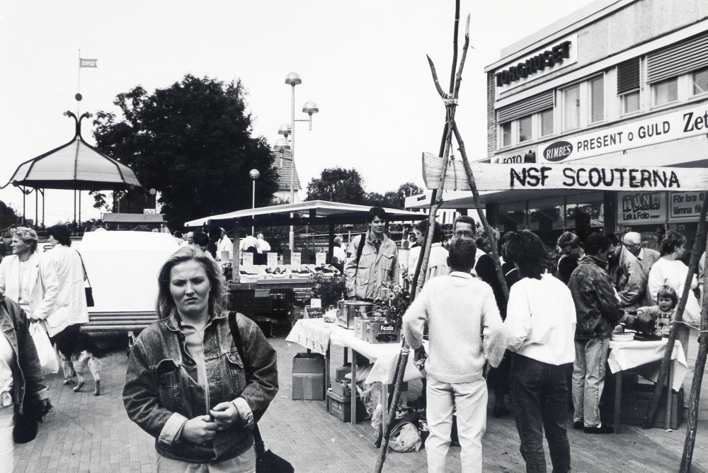 Vallentuna marknad på Tuna torg den andra lördagen i september, arrangerad av Vallentuna hembygdsförening.  Här syns olika stånd, t v NSF scouter, grönsaksförsäljning och folkvimmel