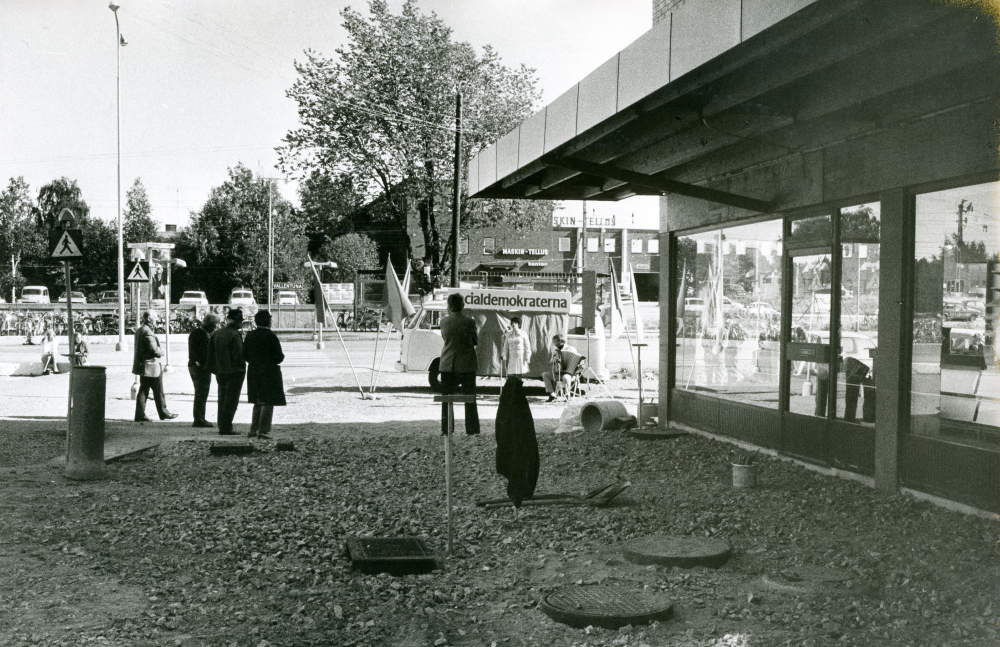 Socialdemokraternas valbuss har stannat till vid nya Tunahuset för ett lunchmöte. Två representanter bjuder på dragspelsmusik och sång.
•Fotografiet ingår i bildserien ”Vardagsliv i Vallentuna kommun” av Rachael Gough-Azmier & Gunilla Blomé, Haga Studios HB.