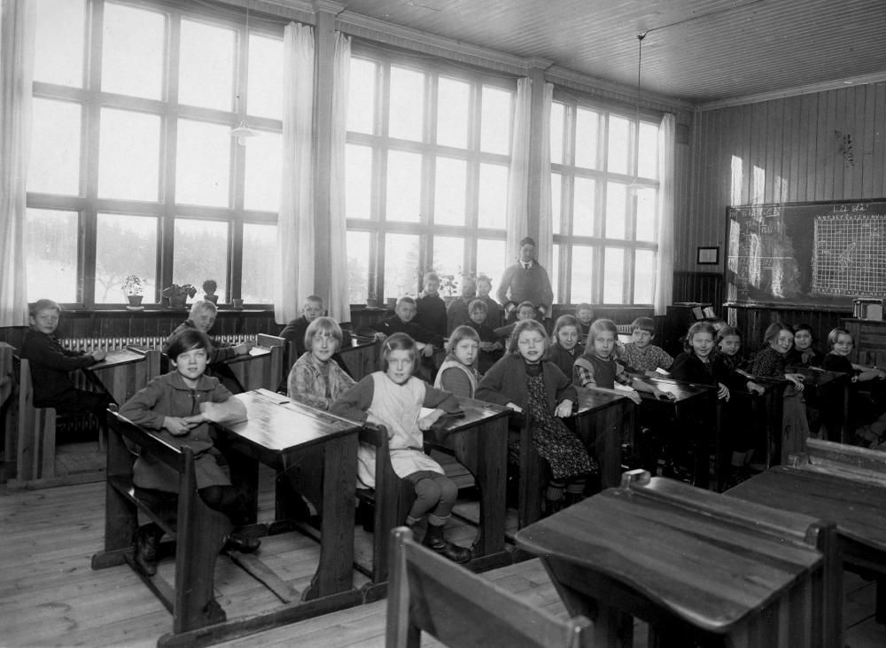 Skolbarnen samlade i klassrummet i Hjälmsta skola  tillsammans med läraren Josef Andersson      Originalfotografiet skadat av vikning