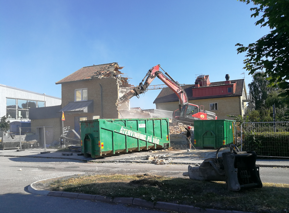 Rivning av den gamla läkarstationen vid Gärdesvägen / Allévägen, sett från Allévägen. I byggnaden fanns även en polisstation med ingång från Allévägen. På platsen ska byggas ett nytt hus med studentbostäder. I bakgrunden till vänster skymtar Vallentuna Kulturhus.