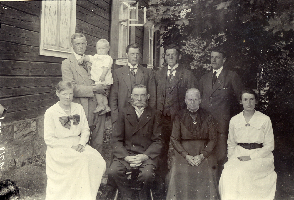 Severin och Josefina Carlsson med familj utanför Karlbergs handelsbod i Frösunda. 1888 lät han stycka av sin tomt och affären fick fastighetsbeteckning Torsholma 2:6.  I övre raden står fr v sönerna Efraim med sonen Bengt, Herbert, Holger och Allan, alla med efternamnet Céwe (efter faderns förnamn).  I nedre raden sitter fr v Ellen, Efraims hustru, Severin och hans hustru Josefina samt dottern Natalia (Taja), senare gift Helgöstam