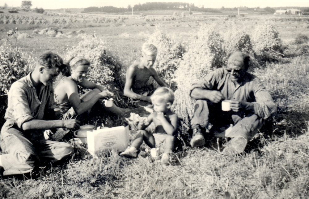 Kafferast bland havreskylarna på åkrarna vid Stensta.   Marken tillhör gården Kårstaby 4:1.  Fr v sitter drängen Valle Johansson, bördig från Billsta i Frösunda, Svea Andersson, dotter i gården, Ove Pettersson "Slaktar-Ove" från Germania i Kårsta, Lars Karlsson, sommarpojke från Stockholm, Algot Andersson, gårdens ägare och far till Svea.  I bakgrunden t v skymtar Danielssons verkstäder och t h soldattorpet Stensta