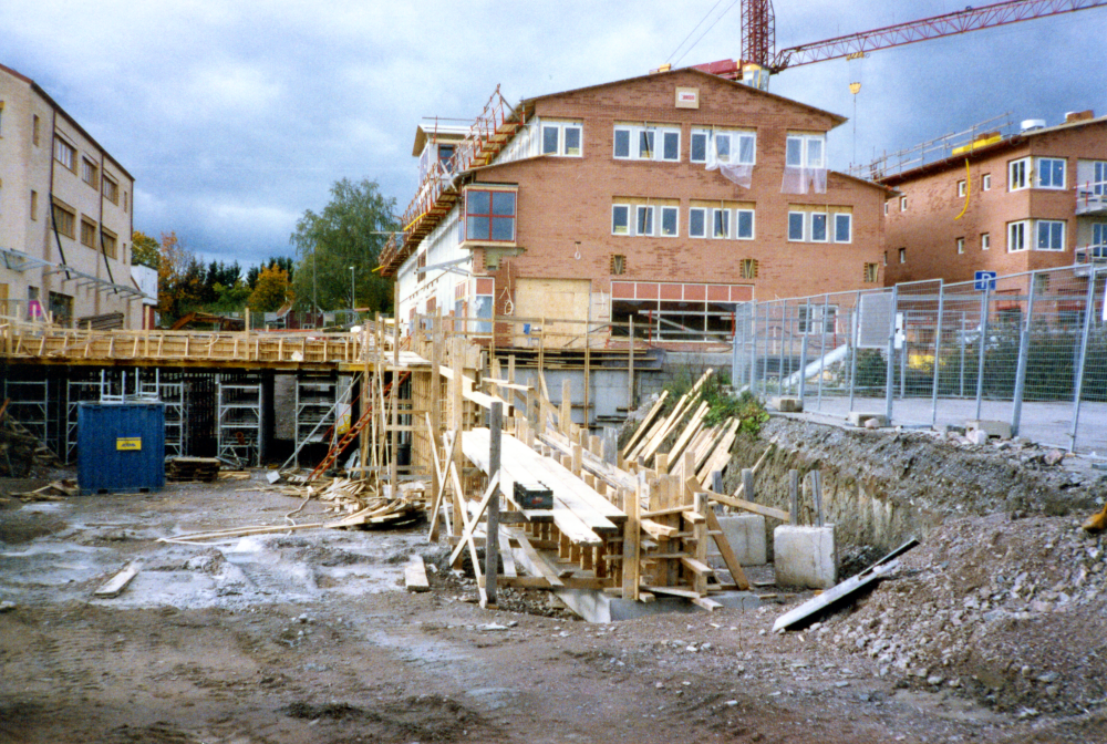 Gammal bebyggelse rivs för att ersättas med nytt. Här syns bygget av Centrumpassagen, ICA-huset till vänster och Systembolagets lokaler till höger.