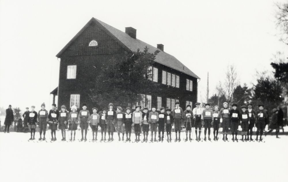 Skidtävling vid Hjälmsta skola. Skidtävlingen var en årligen återkommande händelse och mycket populär, både bland tävlande och åskådare.
Uppgift om fotoår saknas, men troligen 1930-talet.