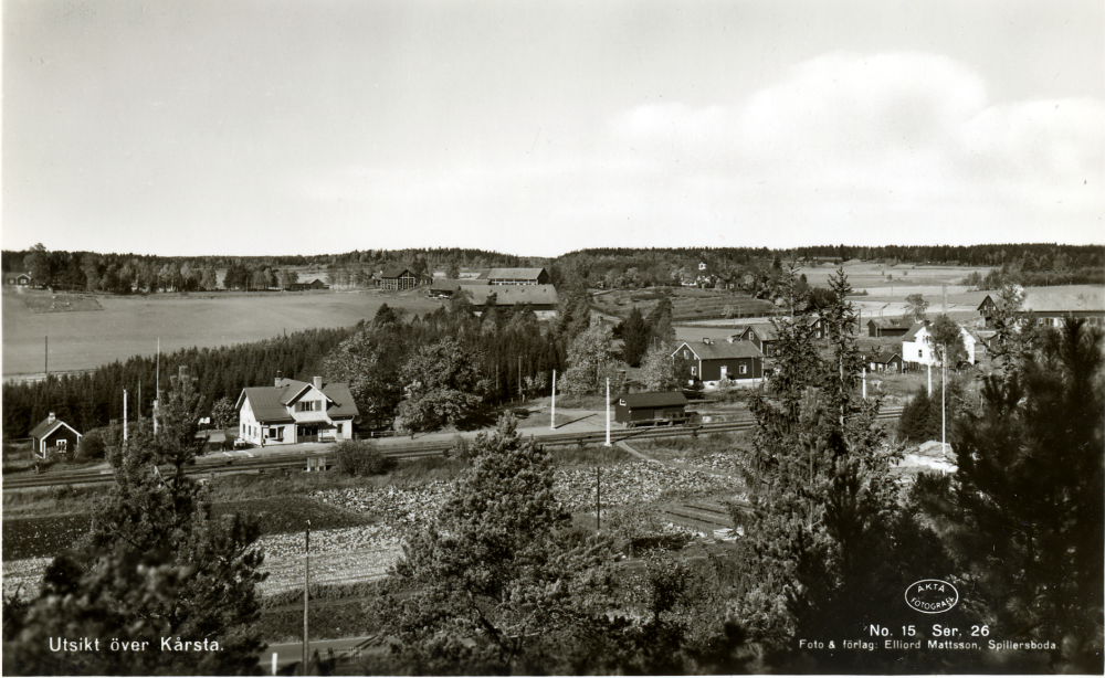 Vy över Kårsta stationsområde med Backa gårds ekonomibyggnader i bakgrunden.  Det röda huset t h om stationshuset är Staffs f d affär som lades ner 1965. Bakom denna skymtar tornet på Backa gård mangårdsbyggnad.