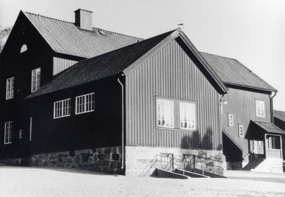 Röda skolan i Hjälmsta byggdes 1925. T h skymtar gaveln på den nybyggda Centralskolan, invigd 1954. 2000 finns skolbyggnaden f fortfarande kvar som Montessoriskola