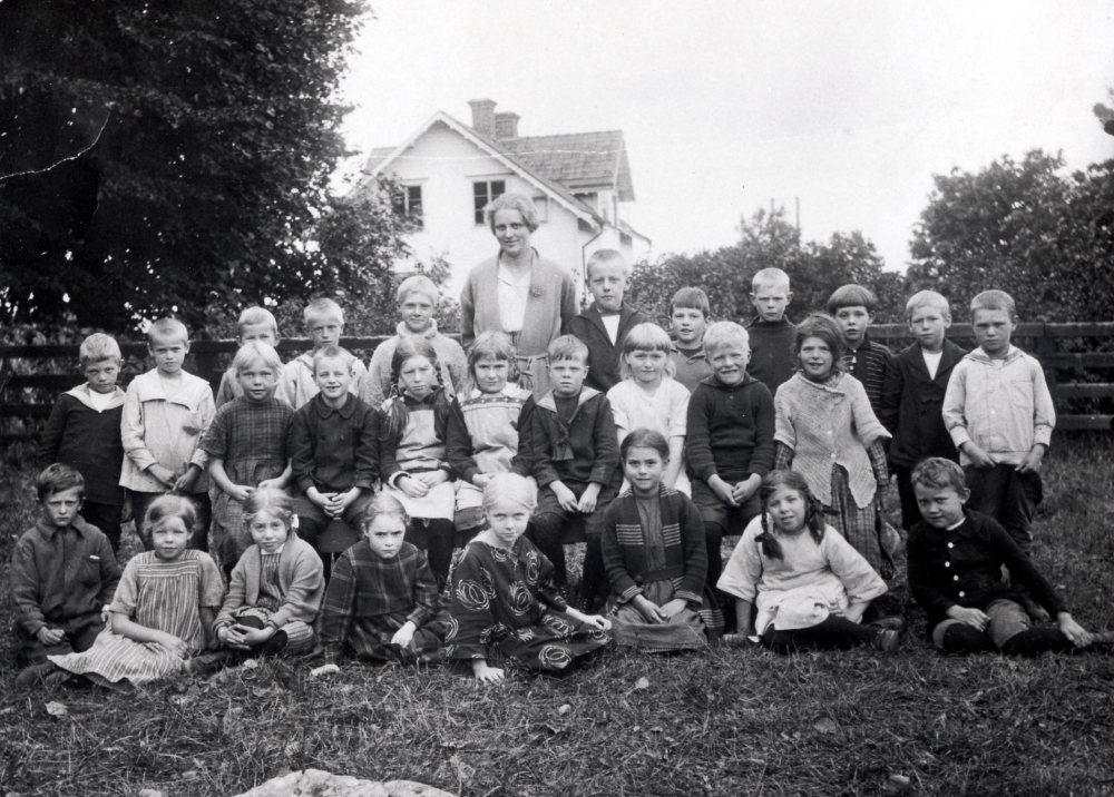 Margit Oppermann med skolbarnen i småskolan vid Vallentuna kyrka.  I översta raden nr 2 från höger sitter Lennart Bornholm, Monica Bloms far.  Margit Oppermann var dotter till stationsföreståndaren i Lindholmen och arbetade som lärare i Vallentuna under hela sin yrkesverksamma tid