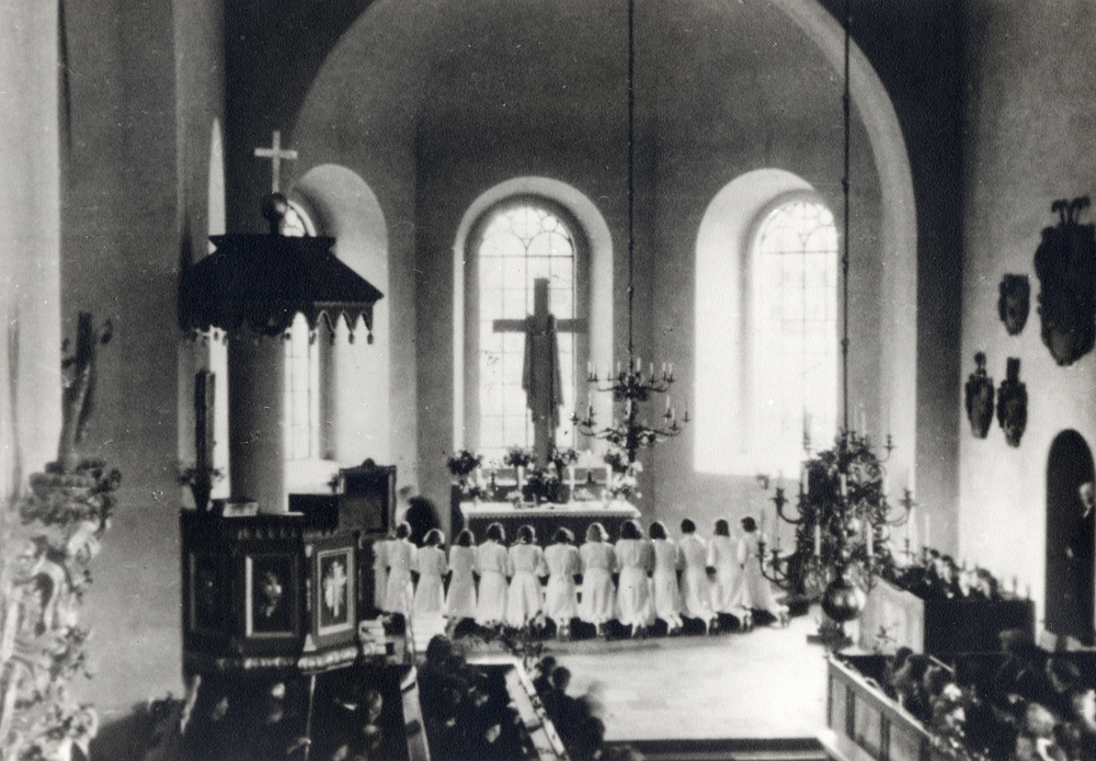 Konfirmation i Vallentuna kyrka. Konfirmanderna har knäfalligt runt altarringer för att motta nattvarden