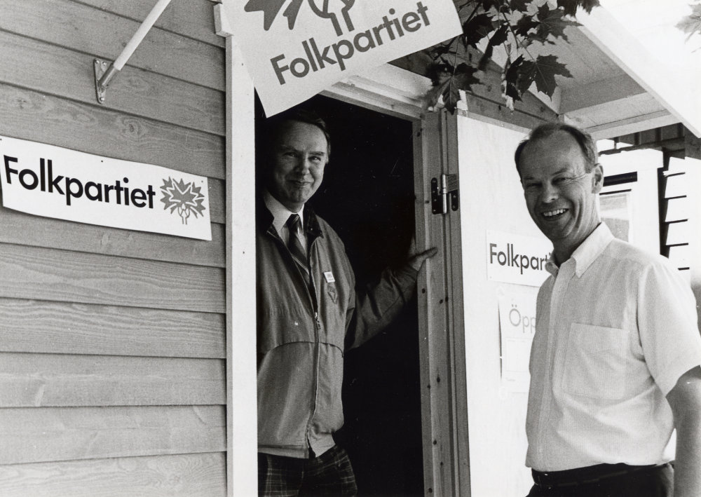 Valinformation på Tuna torg med Folkpartiets valstuga.  I dörröppningen står B O Andersson och t h Staffan Modig