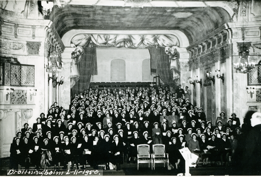 I samband med kung Gustav V död deltar delar av Vallentuna hembygdskör. Bilden är från en repetition på Drottningholm. I ljus kavaj bakre raden, längst till höger står Josef Andersson. Tredje person, till vänster om Josef Andersson, i mörk kavaj heter Arne Lindström. Kvinnan sittandes rakt nedanför honom heter Margareta Thomsson. Personerna stående längst till vänster i främsta ledet, med ansiktena mot kameran är, från vänster, Majken Jansson och Olga Jansson.

Original och uppgifter Kristina Peterson.