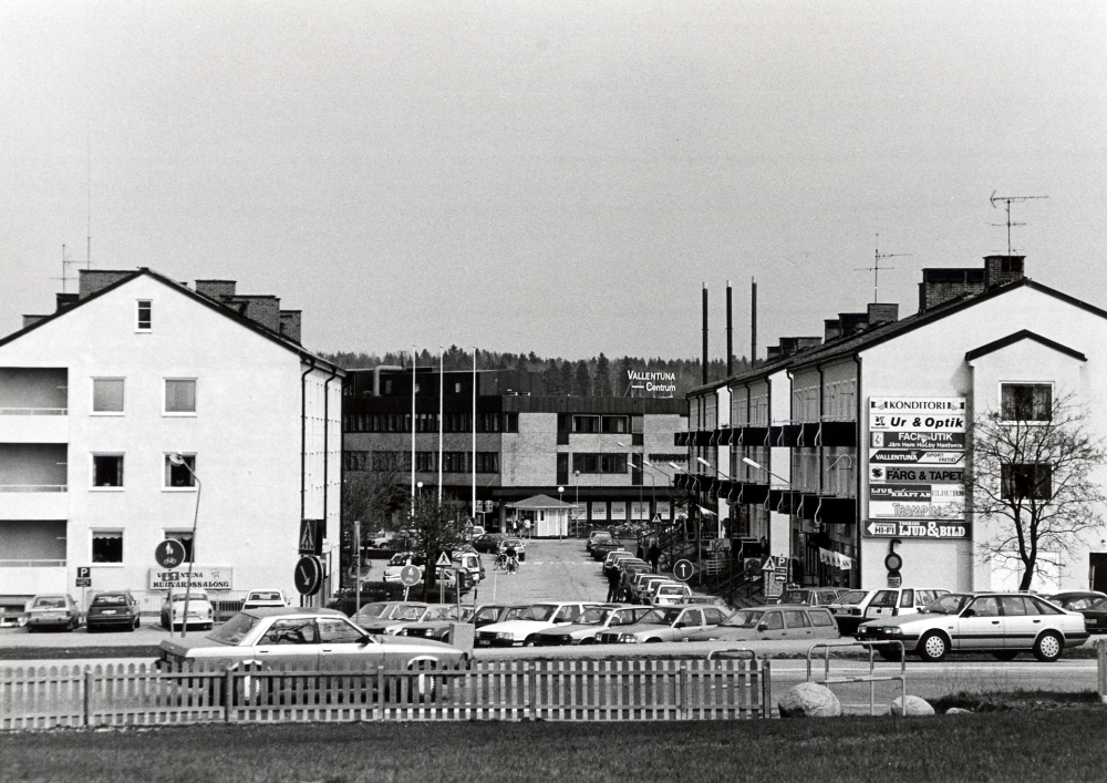 Centralvägen, Vallentunas första affärsgata, sedd från Väsbyvägen. Mellan Centralvägens hus syns Tunahuset och södra delen av Tuna torg