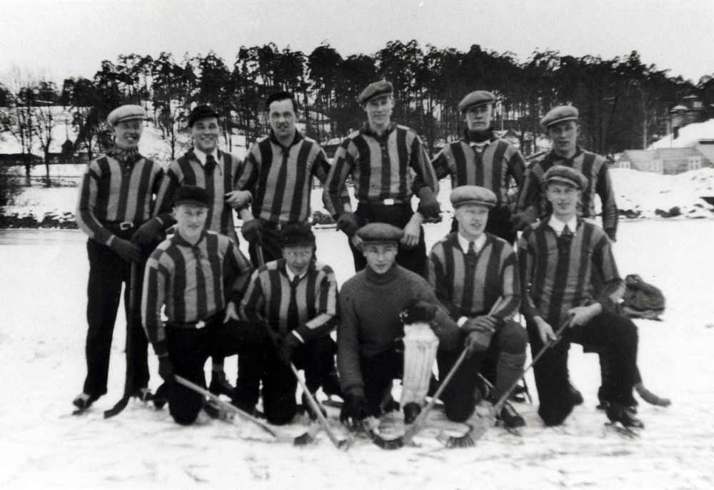 VBK spelar bandy på Värtans is nedanför Skogshögskolan förmodligen i slutet av 1930-talet.  I bakgrunden t h syns Kungl. Skogshögskolans byggnader.  Bakre raden fr v Sven "Lundby" Andersson, Harry Fors, Göran Nordström, Gustav Karlsson, Evert Krieg och okänd.  Nedre raden fr v Charles Östervall, drunknade 1942, okänd, Knut Johansson, okänd och okänd