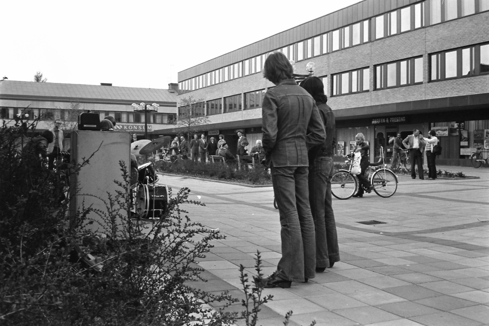 Tuna torg 1976 med Tunahuset till höger och Torghuset i bakgrunden till vänster.
•Fotografiet ingår i bildserien ”Vardagsliv i Vallentuna kommun” av Rachael Gough-Azmier & Gunilla Blomé, Haga Studios HB.

