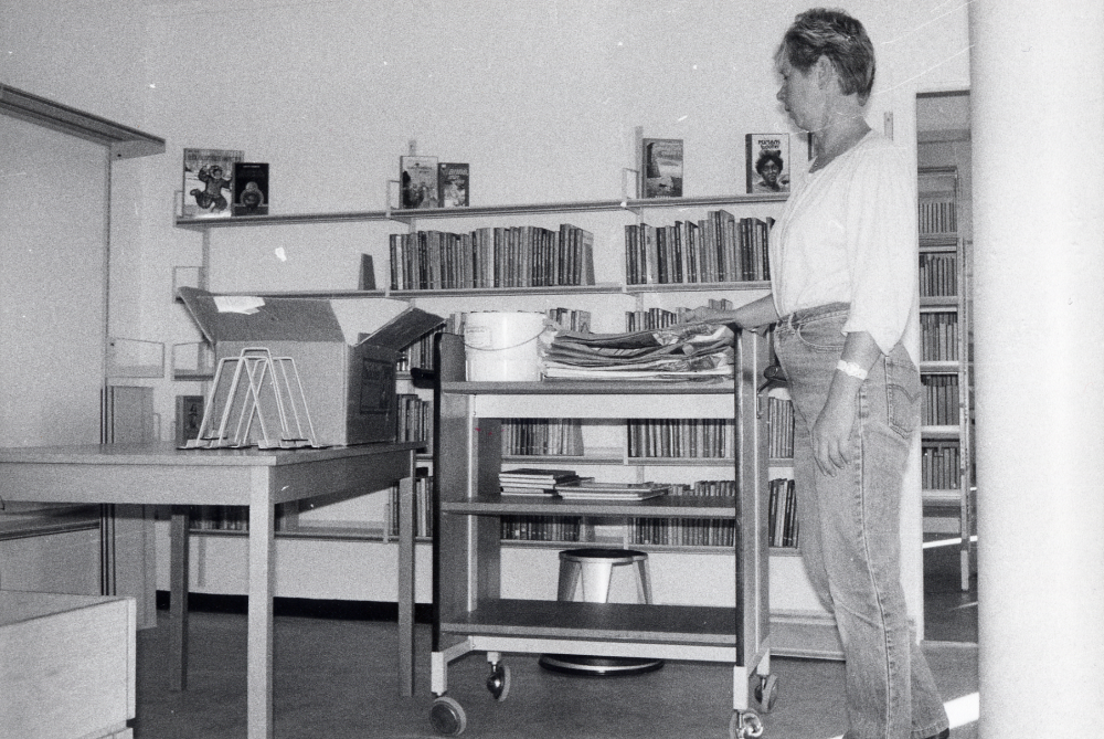 Karby bibliotek har reparerats sommaren 1987 och skall invigas med öppet hus 25 oktober. Vartefter hyllorna sätts upp, plockas böckerna in i hyllorna igen. Gunvor Svensson sätter upp ungdomsböcker i den nya barn- och ungdomsavdelningen