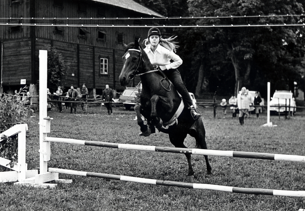 Vallentuna ridklubb  tävlar vid  Löfsta säteri.  Här hoppar en  häst  med  ryttarinna  över ett  hinder  med två bommar