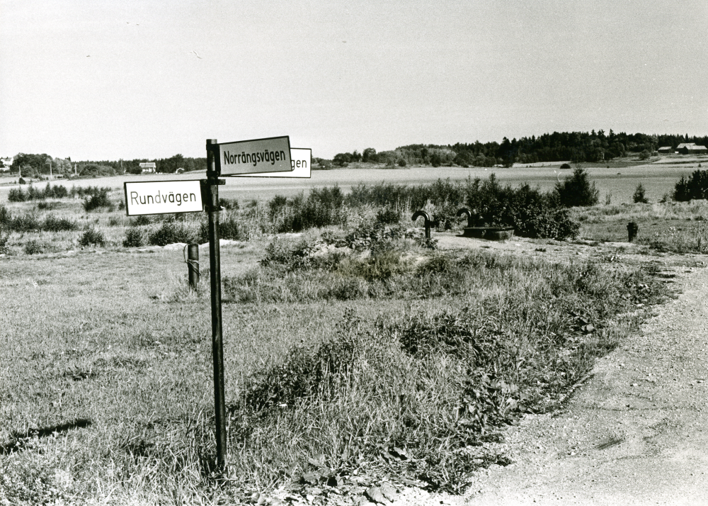 Skyltar med vägnamn på en stolpe vid "samhällets kant", Ormsta. Rundvägen, Norrängsvägen.

•Fotografiet ingår i bildserien ”Vardagsliv i Vallentuna kommun” av Rachael Gough-Azmier & Gunilla Blomé, Haga Studios HB.