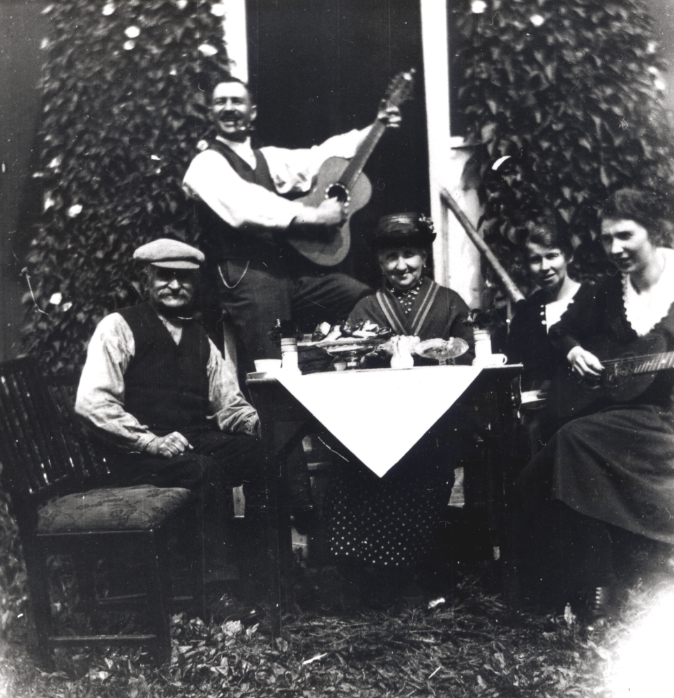 Musikstund vid kaffebordet på Malmberga i Össeby-Garn.  Runt bordet sitter fr v skräddar Malmgren, sonen Ragnar Malmgren som senare bodde i ett hus där Åbybergskyrkan ligger idag, fru Malmgren, Andrea Malmgren och Linnea Malmgren.  Flickorna Malmgren var medlemmar i Betania.

Uppgift om fotoår saknas.