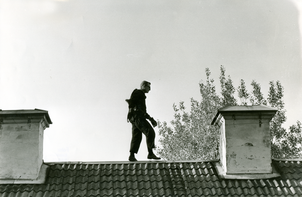 Skorstensfejarmästare Carl-Erik Edlund uppe på ett tak vid Åbyholmsvägen.

•Fotografiet ingår i bildserien ”Vardagsliv i Vallentuna kommun” av Rachael Gough-Azmier & Gunilla Blomé, Haga Studios HB.