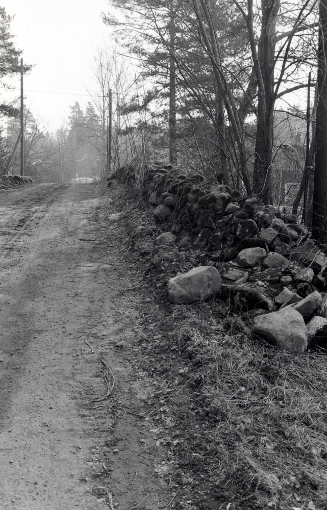 Molnbyvägen mellan Rosenberg och Gustavbergs gård med stengärdsgård.  På vägens vänstra sida skymtar Grindstugan