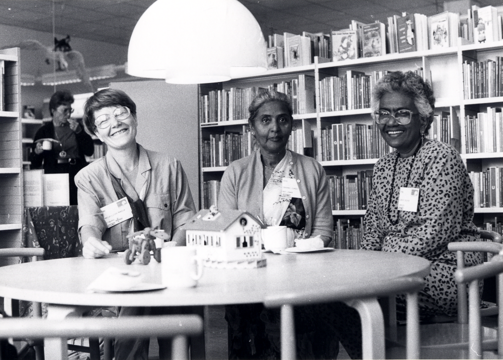 IFLA, International federation of library associations, har förlagt sin konferens i Stockholm 1990.  Bland förslag till utflykt fanns en rundtur i Vallentuna med besök på Vallentuna bibliotek och vikingalunch på Stora Benhamra. Tre av deltagarna sitter här i barnavdelningen vid         kaffepausen i samband med visningen av bibliotekets lokaler