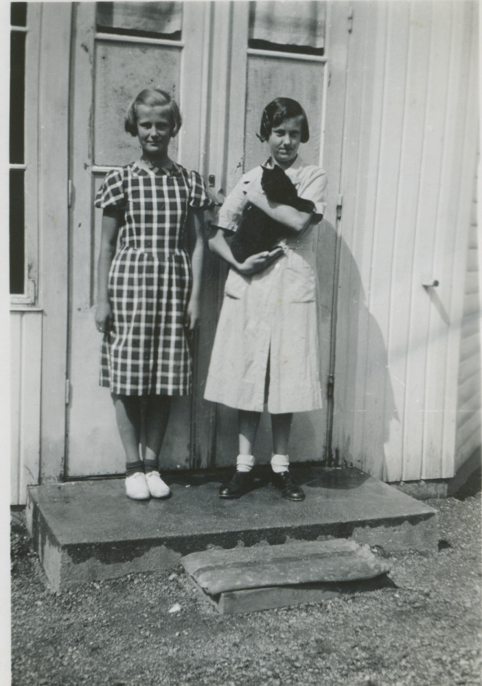 På trappen till Vada affär står Maj-Britt "Britta" född 1924-08-25 och Maj-Lis (med katt i famnen) född 1922-06-03, döttrar till Sally och John Johansson som ägde affären. John drev även taxirörelse och skolskjuts. Affären stängde 1961.