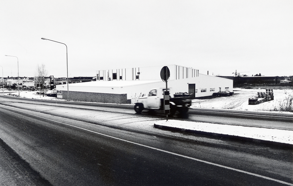 Upplands motor AB med adress Smidesvägen 2 vid Angarnsvägen. Företaget säljer volvo- och renaultbilar samt har en reparationsverkstad. På området finns också en bensistation, Q8. Här syns företagets byggnader från öster i Angarnsbacken