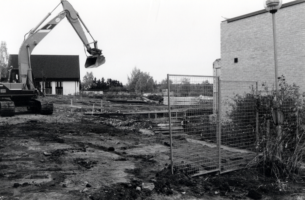 Vallentuna centrum vid Tuna torg byggs ut mot norr. Det vita huset t v är Pingstkyrkan, t h skymtar förrvaltningshuset Tärningen skall byggas till, samtidigt pågår grundarbeten för ett nytt hus för bostäder, företag och affärer, bl a det omdiskuterade Systembolaget mellan Tärningen och kyrkan
