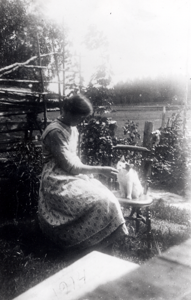 Judit Widén med katten Sara vid Sjöberg i Frösunda.  I bakgrunden syns "Wahlströms åker"