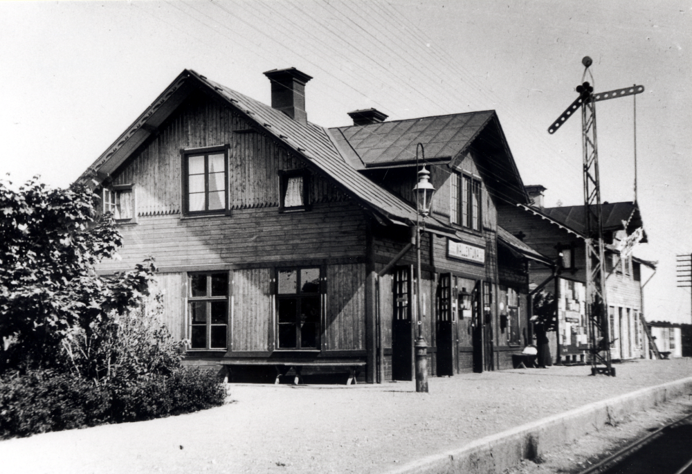Vallentuna järnvägsstation med järnvägsrestaurangen t h.  Framför stationshuset står en semafor