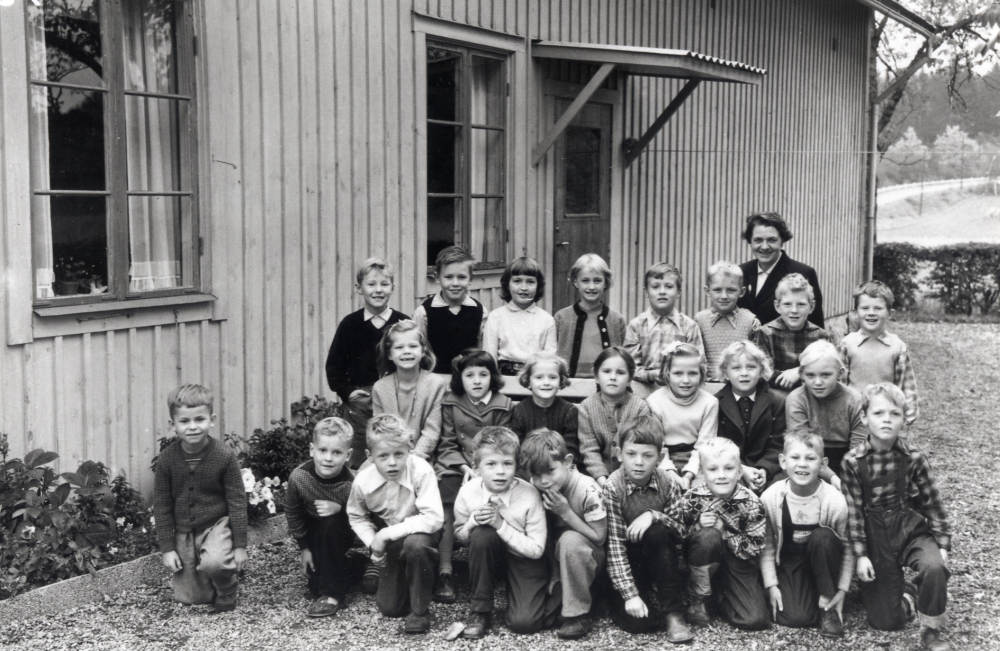 Lärarinnan Vera Eliasson tillsammans med skolbarnen utanför Markims småskola, byggd 1896