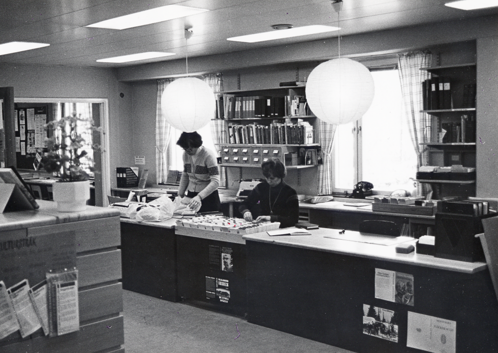 Morgonarbete i låneexpeditionen i Vallentuna bibliotek . Fr v Ulla Mörk och Gunvor Svensson. Biblioteket låg 1 trappa upp ovanför Konsum, nuvarande Torghuset