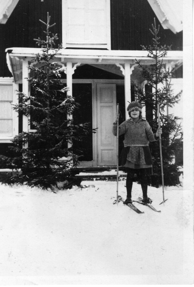 Maj Linder på skidor utanför Påtåker i Vallentuna, förmodligen kring jul eftersom det står två granar utanför farstubron