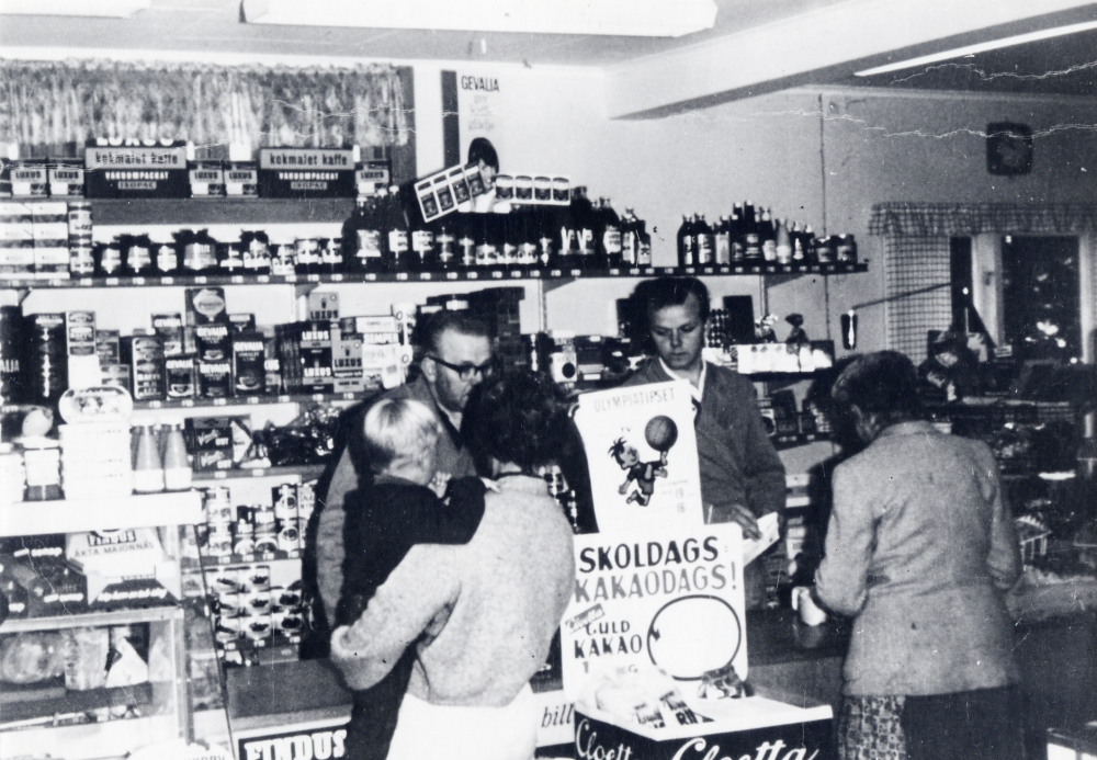 Sigvard Jansson  t v bakom disken i sin affär i  Karlberg   Affären är nyrenoverad efter en brand 1959. T v bakom disken står sonen  Bengt-Arne Jansson