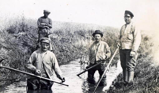 Fyra män som rensar dike med lie, foto från 1920-talet, källa Valletnuna bildarkiv