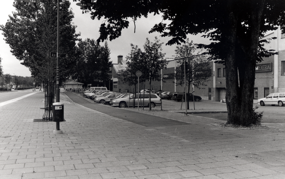 Banvägen efter ombyggnaden 1999-2000 med nybyggd parkering bakom Konsumhuset  i bildens mitt .  Nya träd har planterats bland de äldre nu stora träden, gång- och cykelbanan har fått nytt utseende, liksom utökat utrymme för bussar vid hållplatsen t v