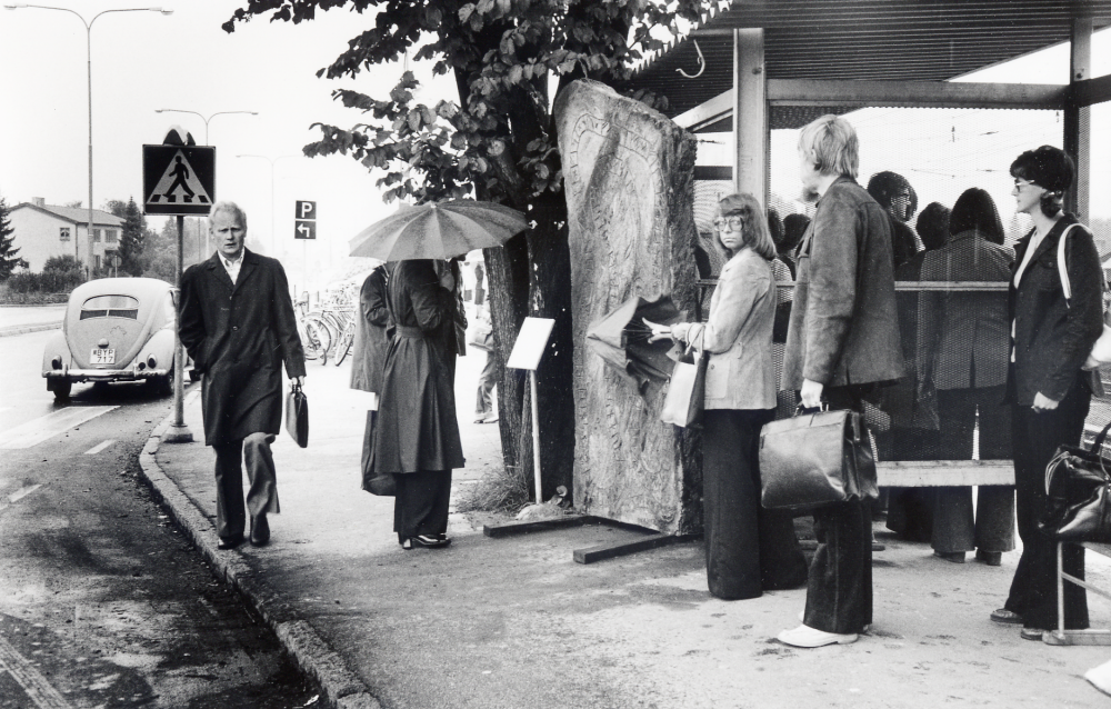 Förvånade resenärer finner en ny runsten vid Vallentuna järnvägsstation rest som protest efter SL:indragning av busslinje 601 mellan Vallentuna och Jarlabankes bro. Vallentunas nyaste runsten restes natten mellan den 11 och 12 september 1975. Initiativtagare till stenen var Bo G Eriksson och Anthony Eyre. Roberto Dünkelberg översatte texten till runor. Texten på stenen lyder: Resande reste rasande stenen, snöda skrymtare snodde knarr folkvalde vise nu vanligt vett  Vallentuna väntar på bussen Gud hjälpe SL  Ante högg
