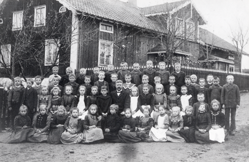 Läraren Fritiof Sundell tillsammans med skolbarnen utanför Kårsta skola