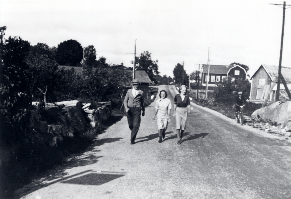 Deltagare i Riksmarschen tågar förbi ladan i Övre Lundby.  I bakgrunden syns småskolan i Angarn.  Marschen ägde rum 1941 och var ett säreget arrangemang för att höja medborgarandan.  Män marscherade 15 och kvinnorna 10 km inom en bestämd tid.  Poängen räknades i relation till Sveriges och Finlands folkmängd. Många deltog i traditionell Sverige-Finland friidrottsanda.  Finlands president och statsminister deltog under stor mediebevakning. Sammanlagt deltog 1 507 111 finländare  och vann över Sverige i detta evenemang som var säreget i hela världen.  Man hade lyckats stärka gemenskapsandan.